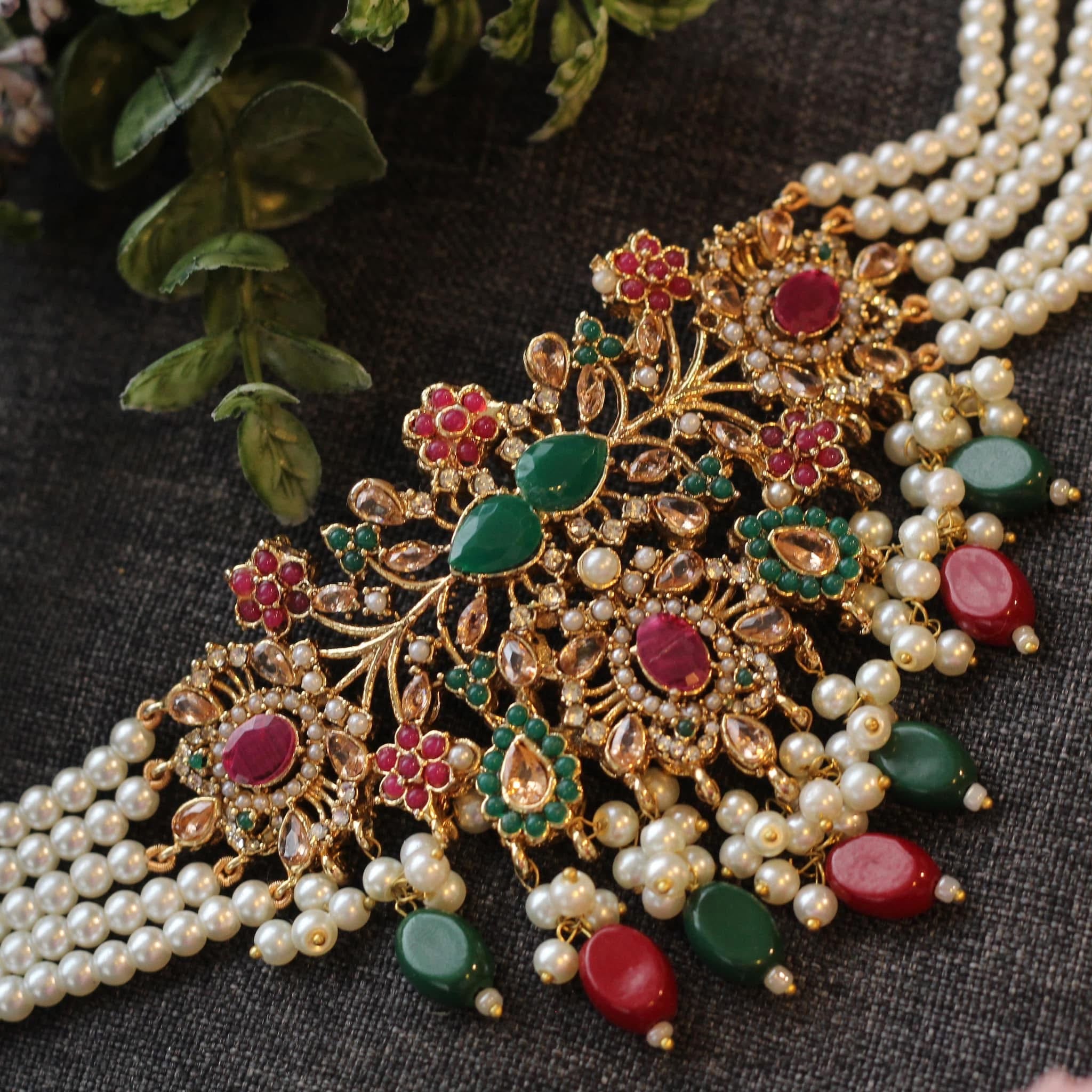 Ornate jewelry piece with pearls, red and green stones