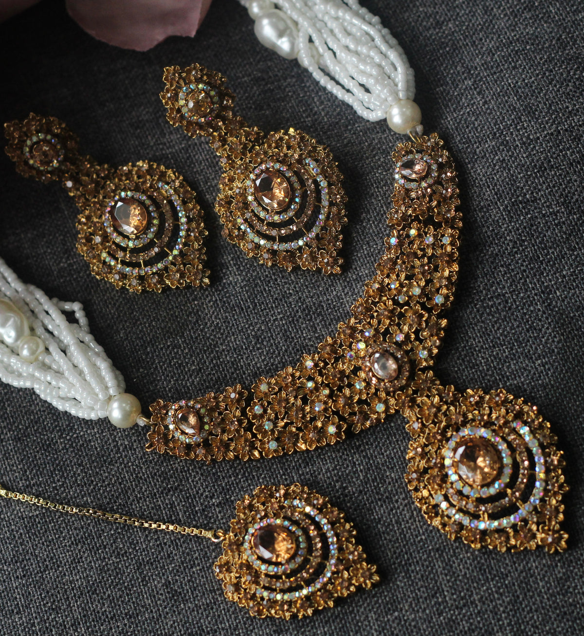 jewelry set, featuring a gold-toned beaded necklace, matching earrings, and a small pendant with white pearl tassels.