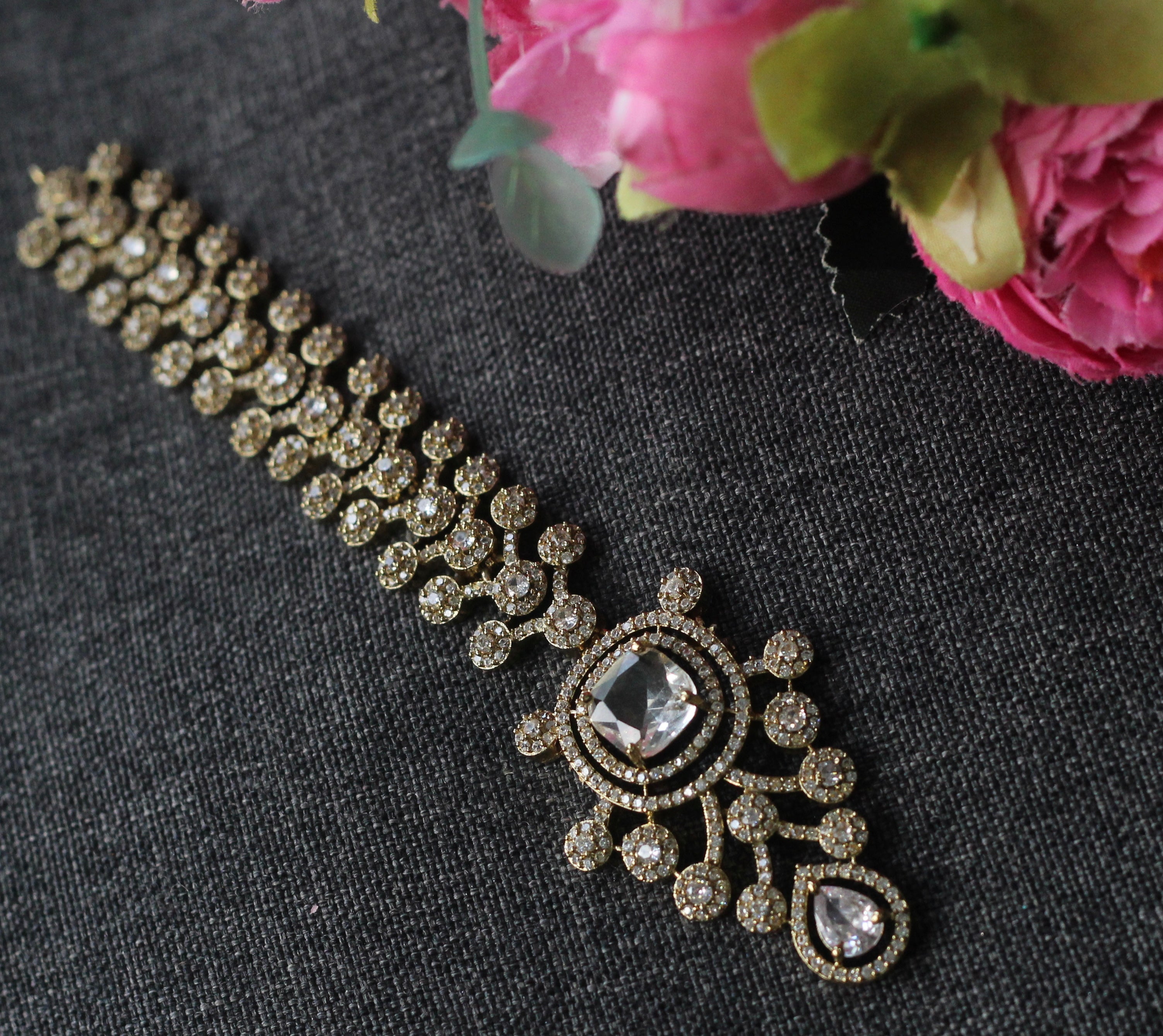 An ornate gold-toned traditional Indian bridal tiara with clear crystals