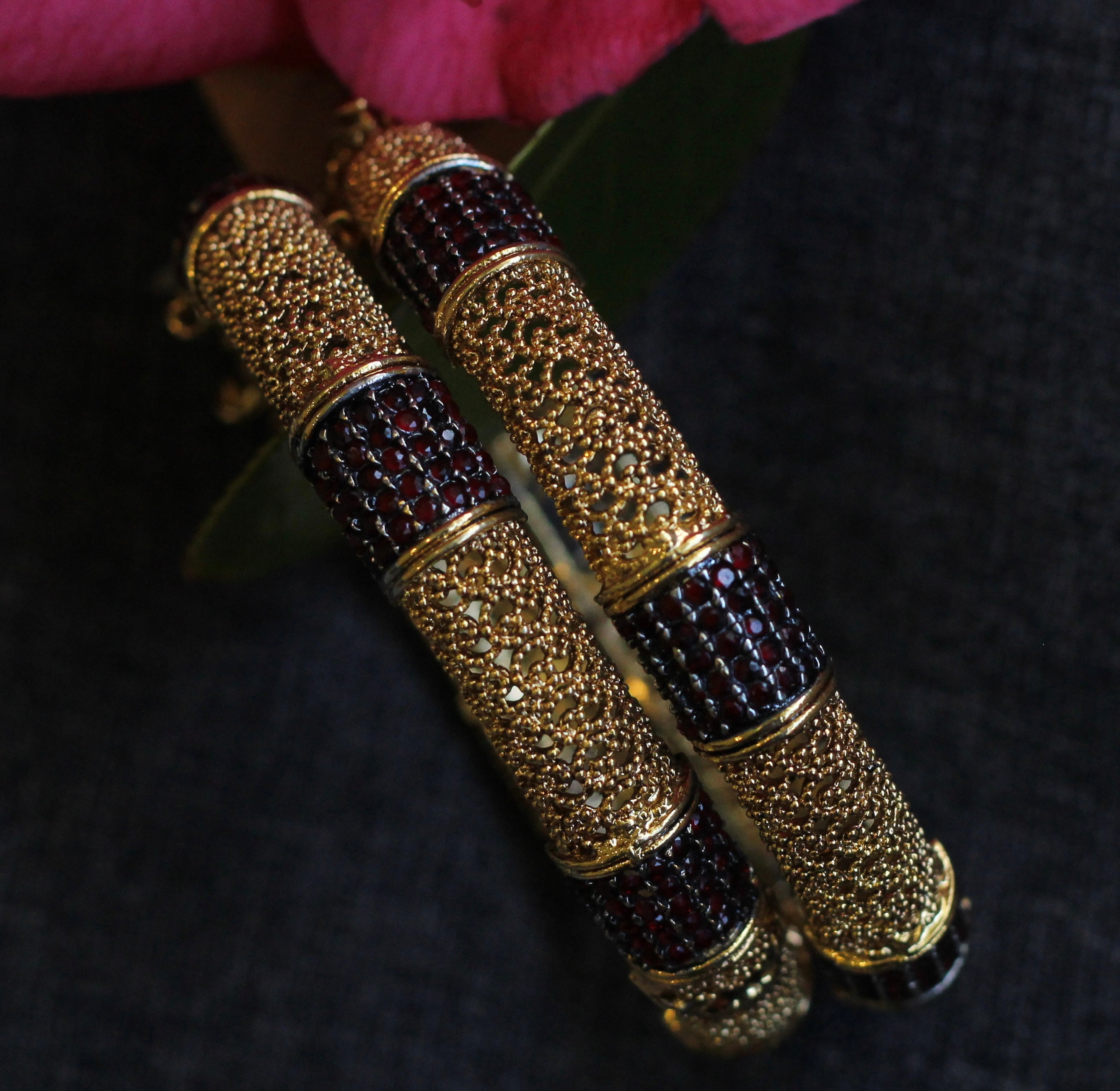 Decorative cylindrical object with gold and black pattern on a dark background