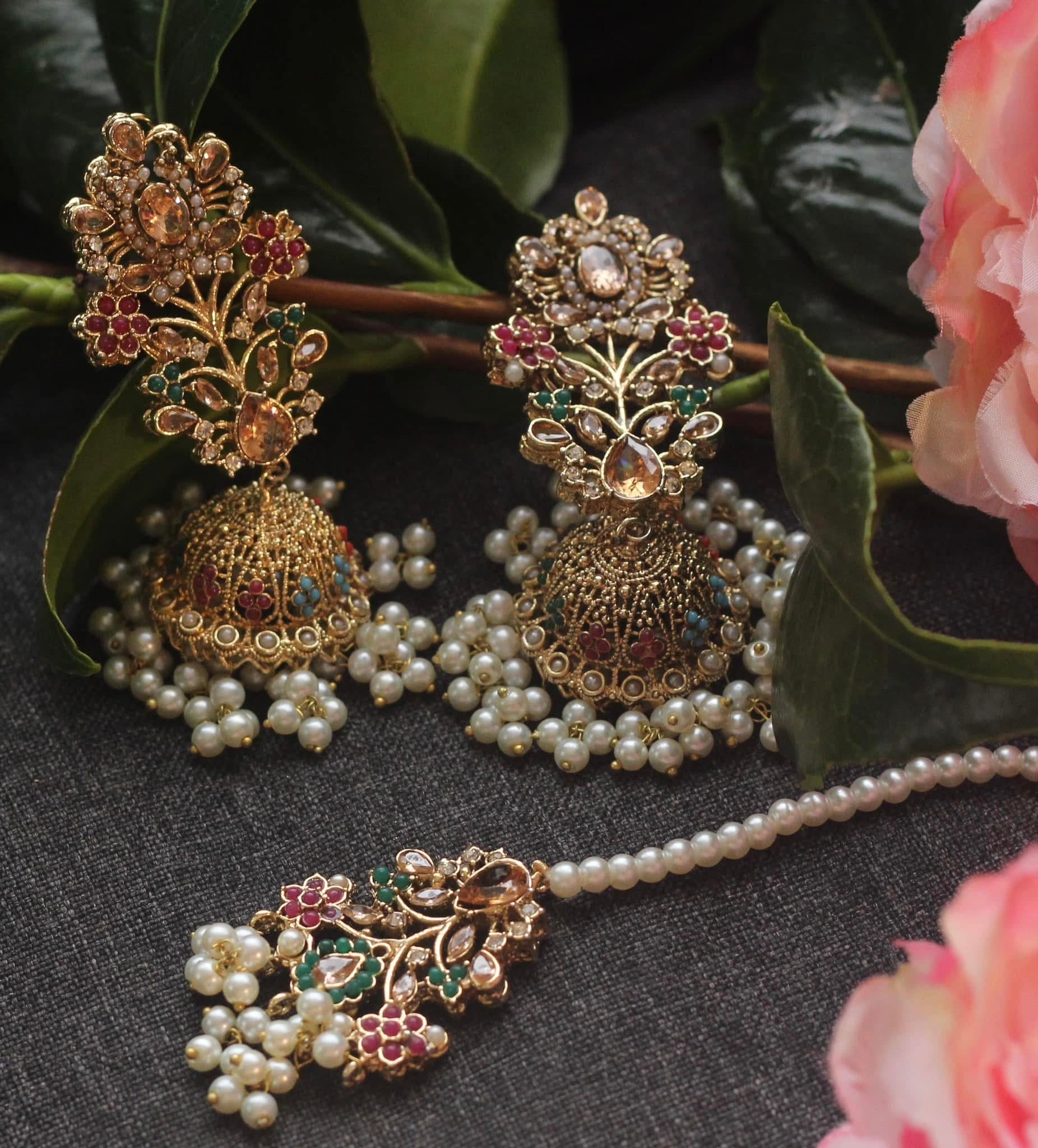 Ornate gold and pearl jewelry set with flowers.